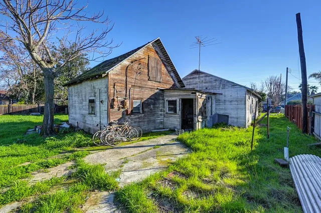 a view of a house with brick walls and a yard with plants