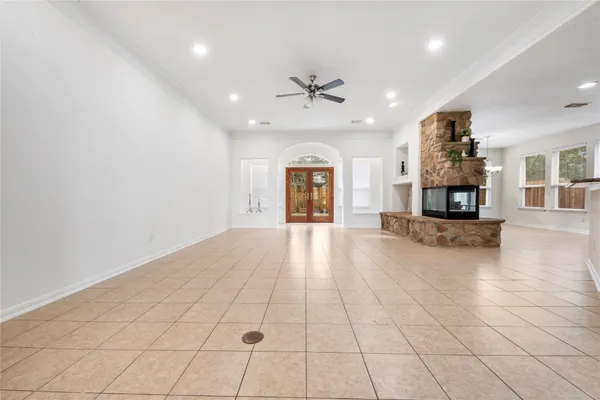 an empty room with a ceiling fan and window