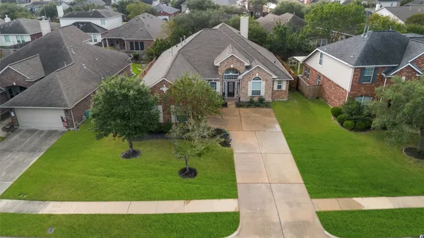 a front view of a house with a yard and green space
