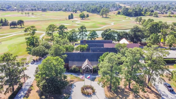 an aerial view of a house with a yard and a large tree