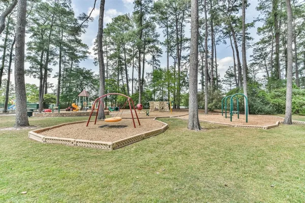 an aerial view of a house with a yard and trees all around