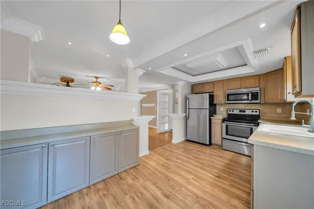 a kitchen with a refrigerator cabinets and wooden floor