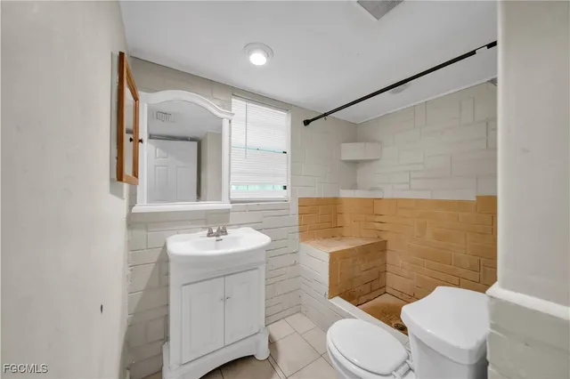 a bathroom with a sink toilet vanity and shower