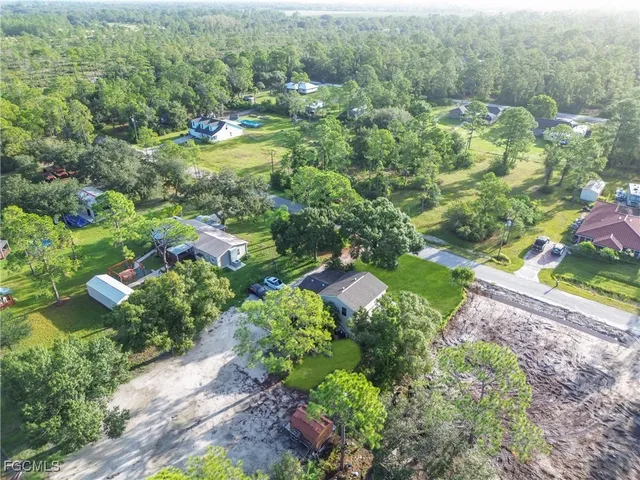 an aerial view of residential house with outdoor space and trees