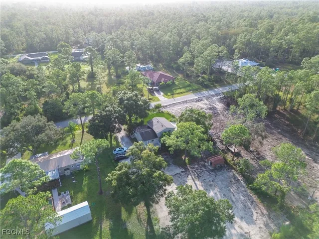an aerial view of a house with a yard and trees