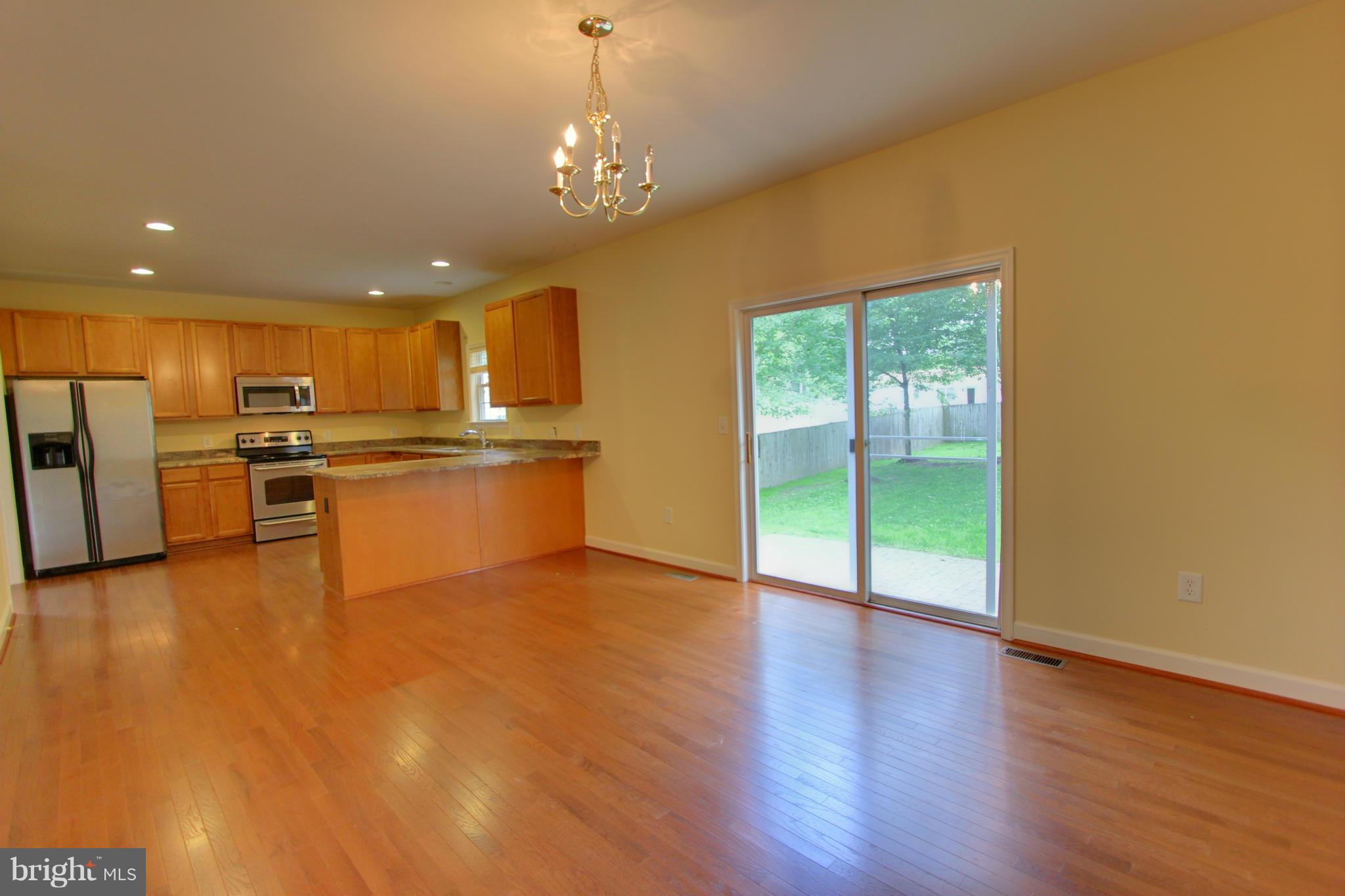 558 Sunset Knoll Road Pasadena, MD 21122 - Photo 11 of 30 a view of a kitchen with a stove wooden cabinets and a living room