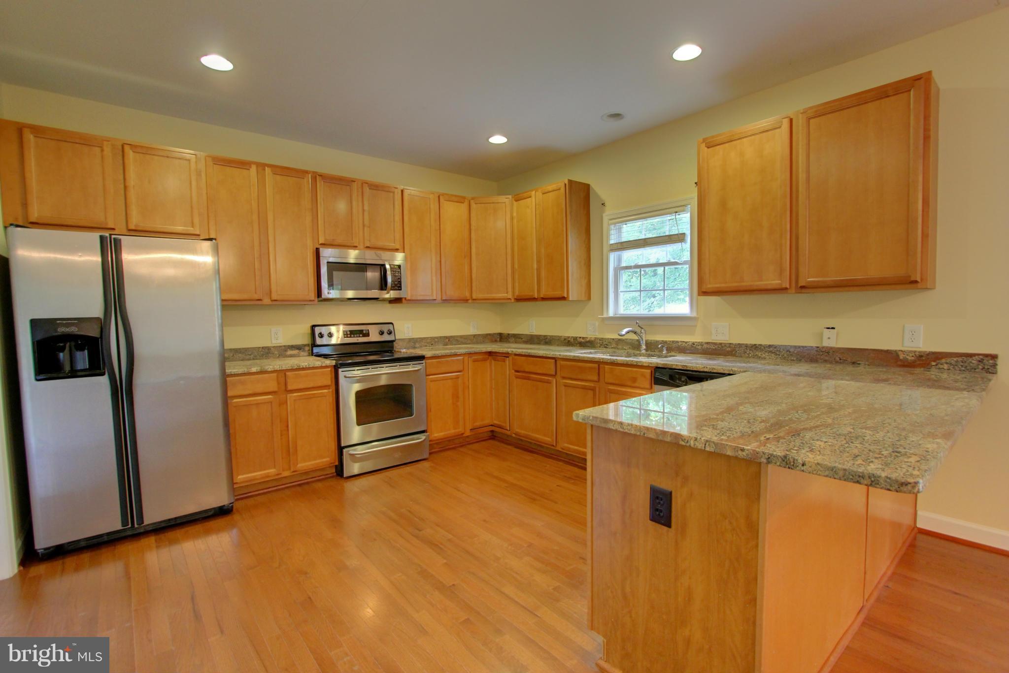 558 Sunset Knoll Road Pasadena, MD 21122 - Photo 12 of 30 a kitchen with stainless steel appliances granite countertop a stove a sink and a refrigerator