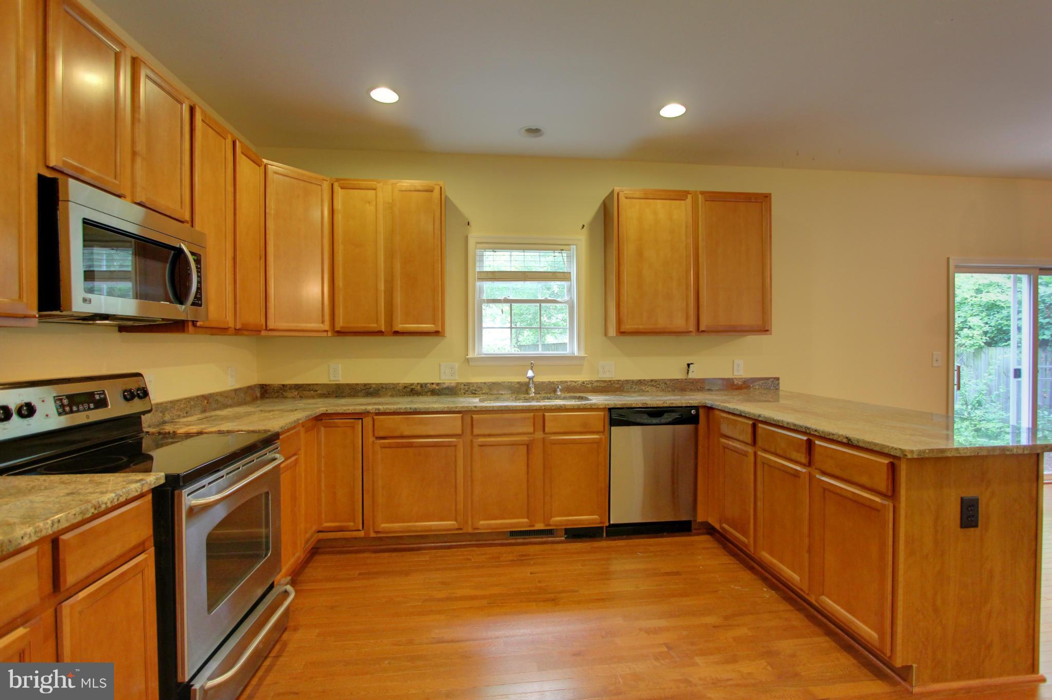 558 Sunset Knoll Road Pasadena, MD 21122 - Photo 13 of 30 a kitchen with stainless steel appliances granite countertop wooden cabinets a stove top oven a sink and dishwasher