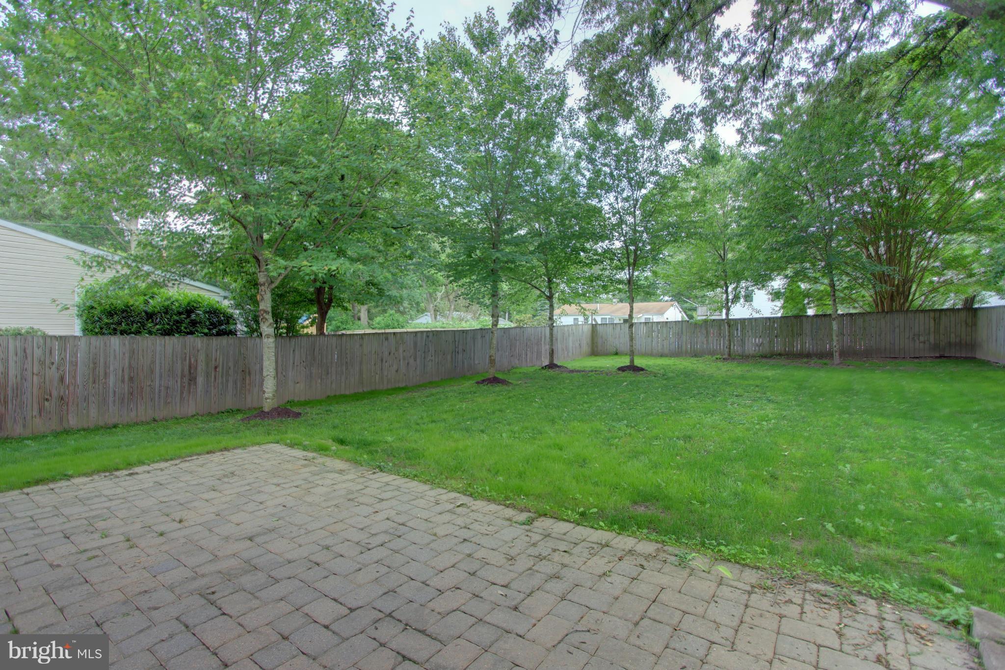 558 Sunset Knoll Road Pasadena, MD 21122 - Photo 3 of 30 a view of a yard with a large trees and a wooden fence