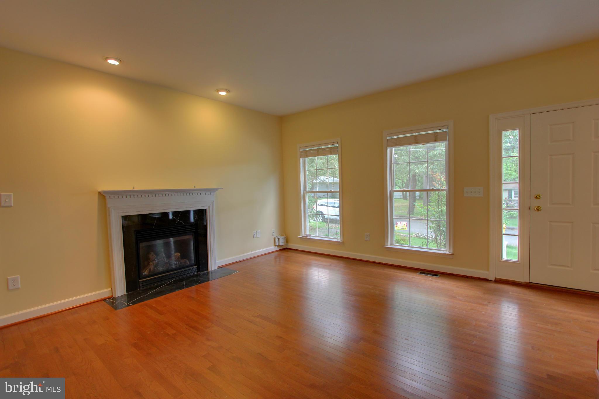 558 Sunset Knoll Road Pasadena, MD 21122 - Photo 7 of 30 a view of an empty room with a fireplace and a window