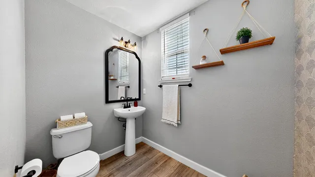 a bathroom with a toilet sink and mirror