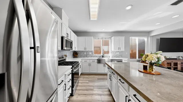 a kitchen with sink a refrigerator and microwave