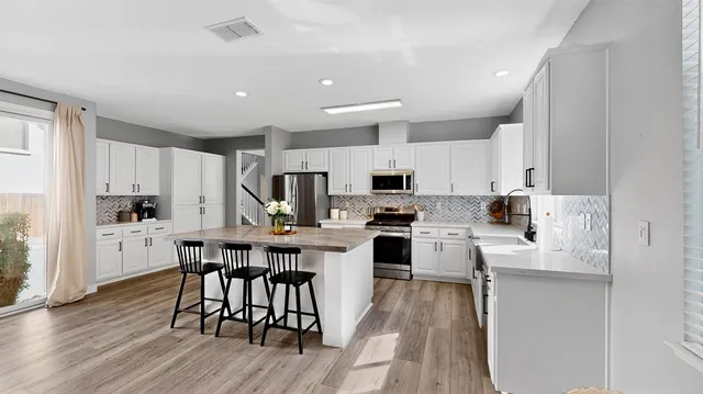 a kitchen with white cabinets and stainless steel appliances