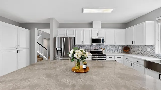 a kitchen with white cabinets and appliances