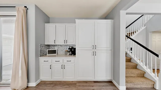 a view of a kitchen with white cabinets and white appliances