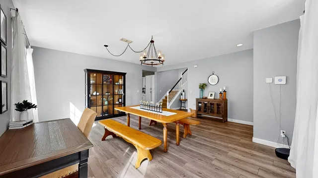 a living room with furniture a wooden floor and a chandelier