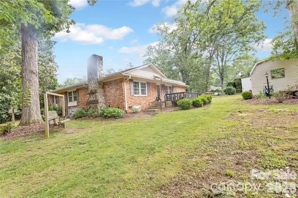 a front view of a house with a garden and trees