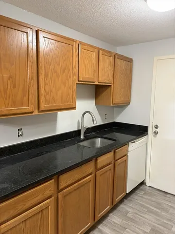 a kitchen with granite countertop white cabinets and sink