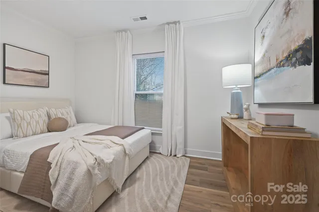 a bedroom with a bed and a lamp on the dresser