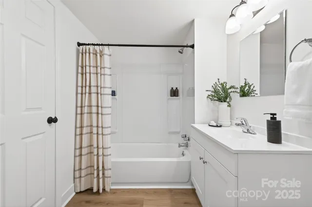 a bathroom with a tub sink and mirror