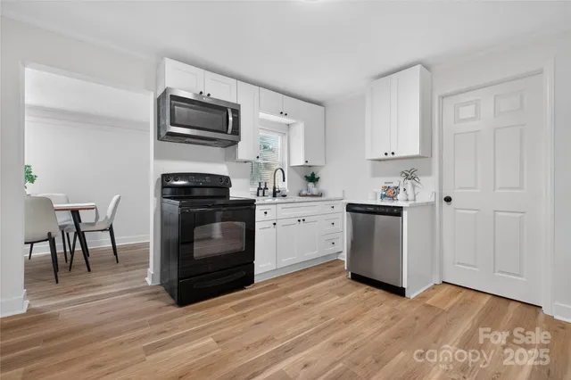 a kitchen with granite countertop a stove a sink and a microwave
