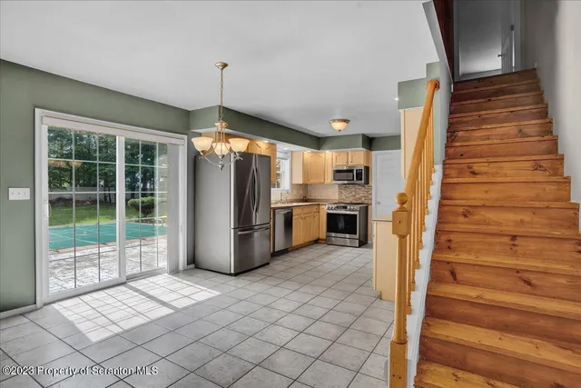 a view of a kitchen with wooden floor and electronic appliances