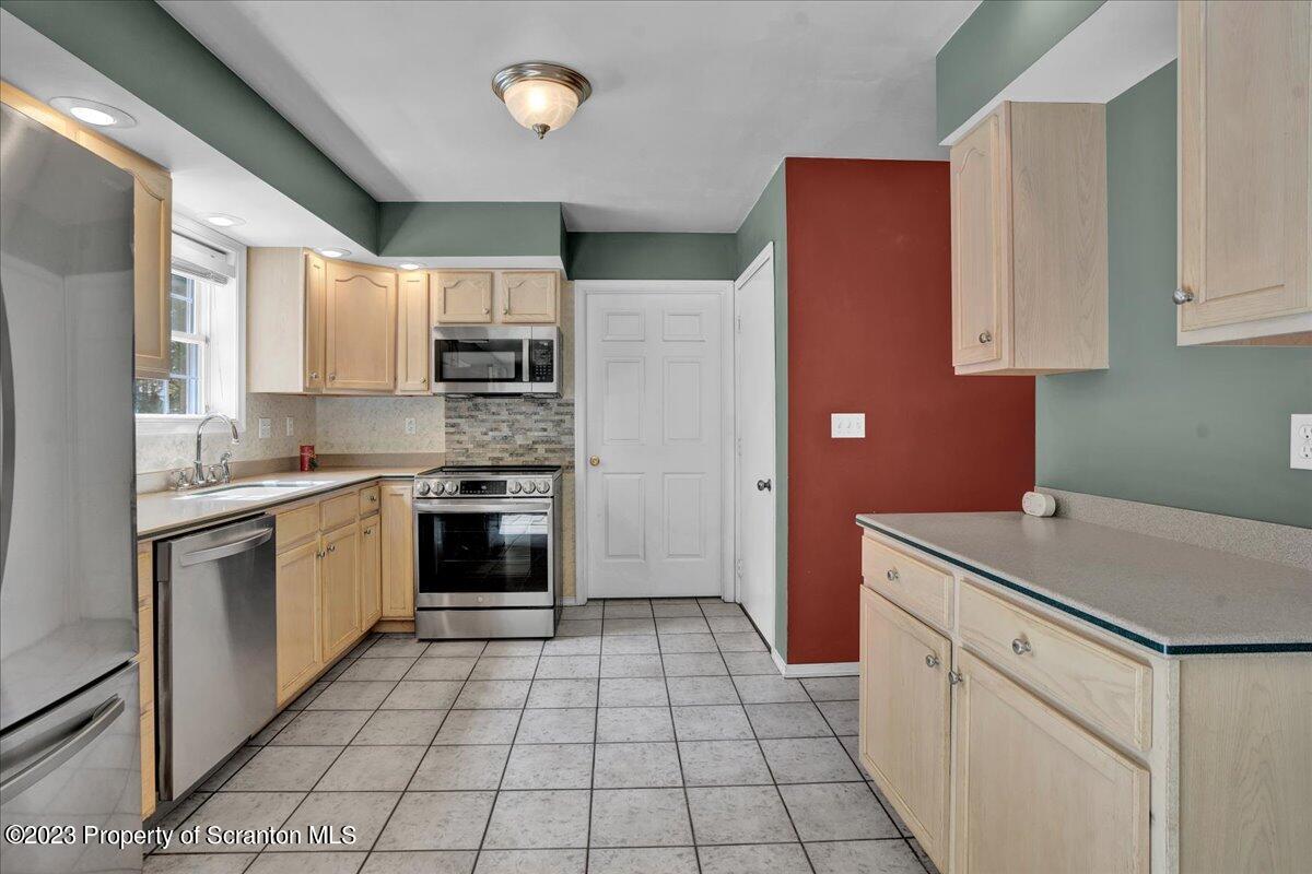 919 Old Logger Road Moscow, PA 18444 - Photo 14 of 36 a kitchen with a sink cabinets and stainless steel appliances