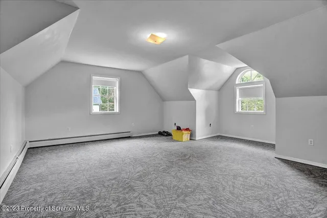 an empty room with windows and fireplace