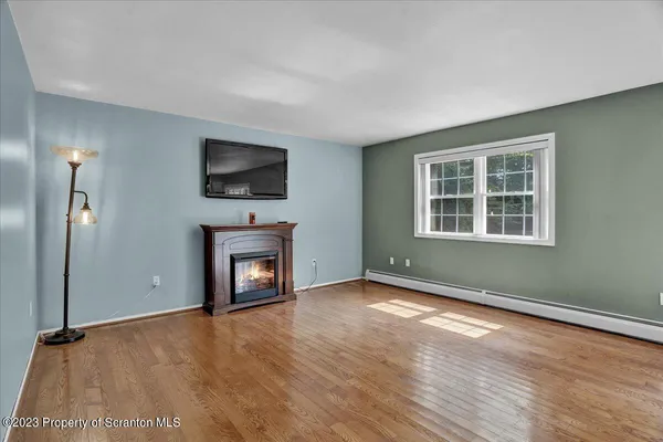 a view of an empty room with window and fire place