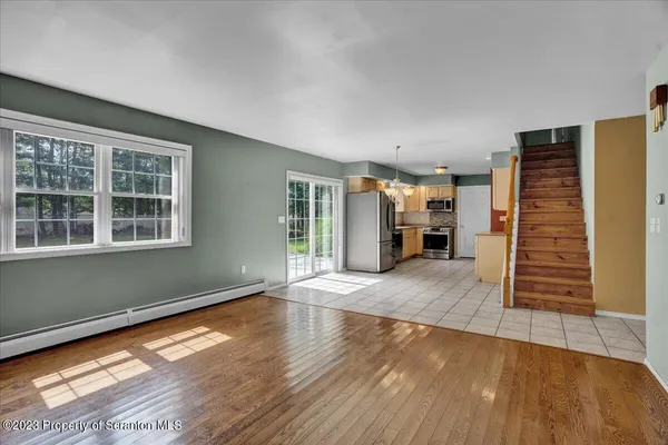 a view of empty room with wooden floor and fireplace