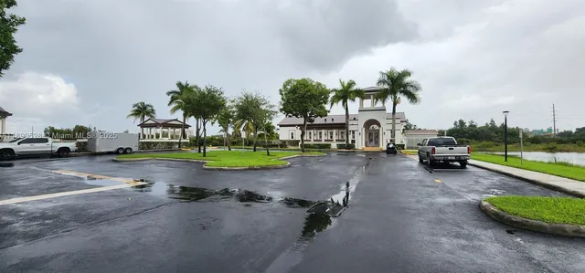 front view of a house with a fountain and a palm tree
