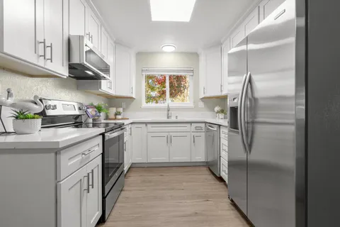 a kitchen with stainless steel appliances granite countertop a refrigerator and a sink
