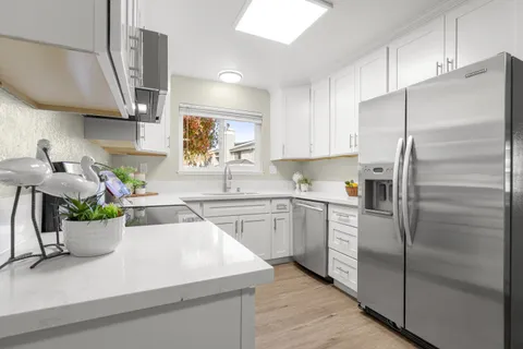 a kitchen with stainless steel appliances a sink a stove and a refrigerator