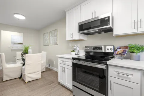 a kitchen with cabinets appliances and a wooden floor