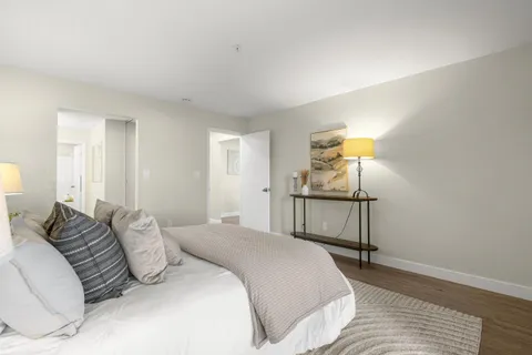 a bedroom with a bed and wooden floor