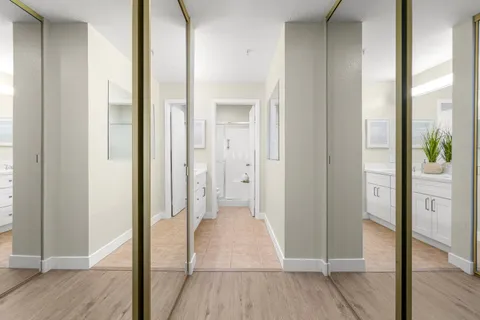 a view of a hallway with wooden floor and closet