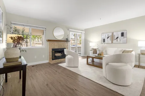 a living room with furniture a fireplace and a large window