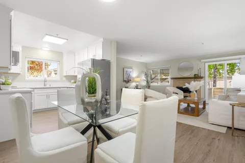 a living room with furniture a dining table and a chandelier