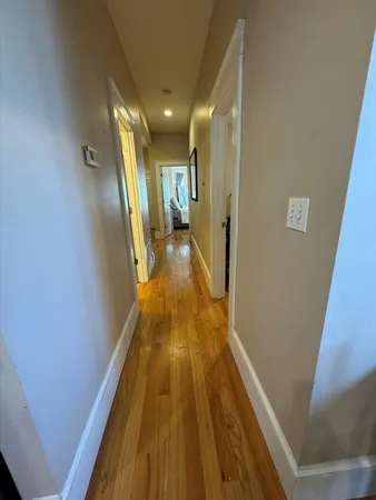 a view of a hallway with wooden floor