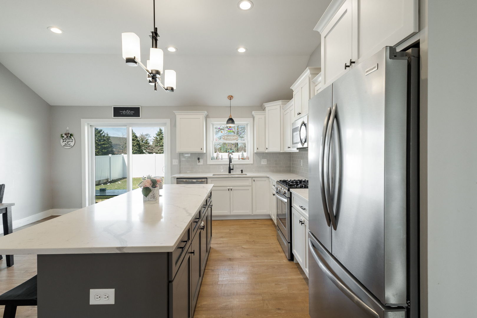 1059 Hummingbird Lane Peotone, IL 60468 - Photo 5 of 30 a kitchen with stainless steel appliances granite countertop a refrigerator a sink dishwasher a stove and white cabinets with wooden floor