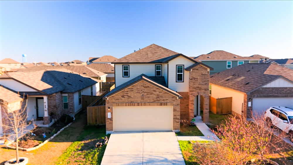 a front view of house with yard and trees in the background