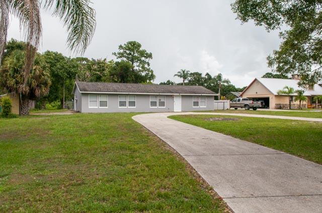 3748 Whiteway Dairy Road Fort Pierce, FL 34947 - Photo 4 of 16 a view of house with a garden and tall trees