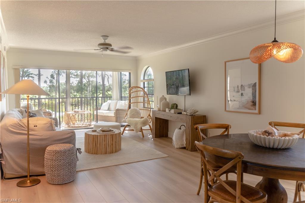 265 Deerwood Circle, Unit 10 Naples, FL 34113 - Photo 2 of 38 Living room featuring light wood-style floors, ornamental molding, and ceiling fan