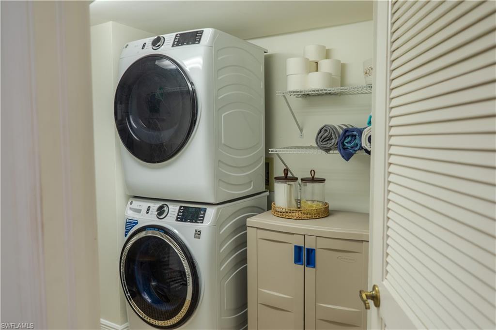 265 Deerwood Circle, Unit 10 Naples, FL 34113 - Photo 30 of 38 Washroom featuring cabinet space and stacked washer and clothes dryer