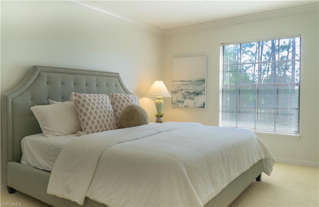 265 Deerwood Circle, Unit 10 Naples, FL 34113 - Photo 33 of 38 Carpeted bedroom with baseboards and ornamental molding
