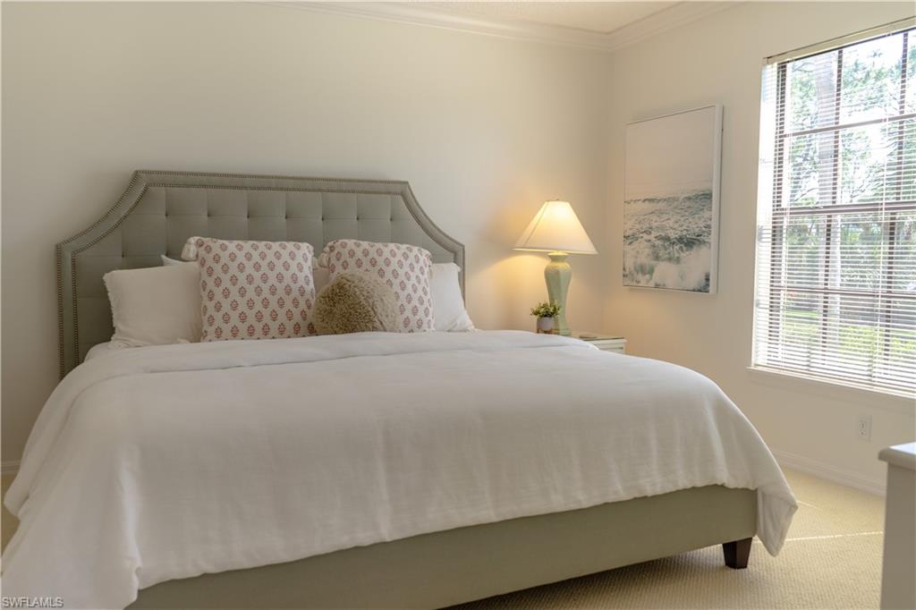 265 Deerwood Circle, Unit 10 Naples, FL 34113 - Photo 34 of 38 Bedroom featuring crown molding, baseboards, multiple windows, and carpet flooring