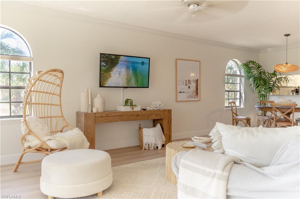 265 Deerwood Circle, Unit 10 Naples, FL 34113 - Photo 5 of 38 Living area featuring light wood-style flooring, baseboards, crown molding, and ceiling fan