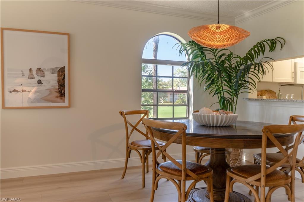 265 Deerwood Circle, Unit 10 Naples, FL 34113 - Photo 9 of 38 Dining room featuring light wood-style floors, baseboards, and ornamental molding