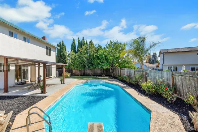a view of a house with backyard and sitting area
