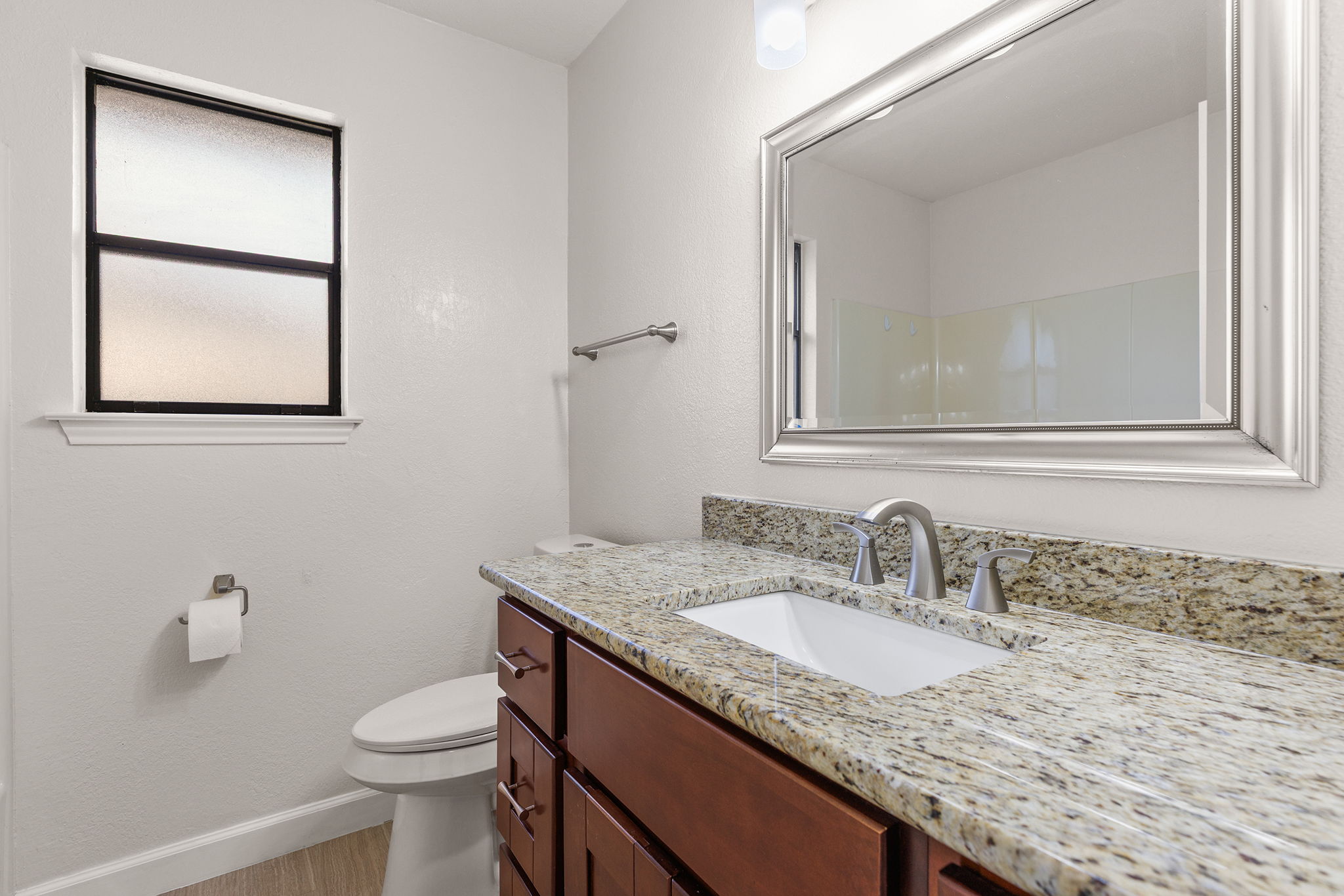 2409 Water Well Lane Austin, TX 78728 - Photo 18 of 22 Bathroom featuring a wood-finish vanity with a light-toned granite countertop, undermount sink, and brushed nickel hardware
